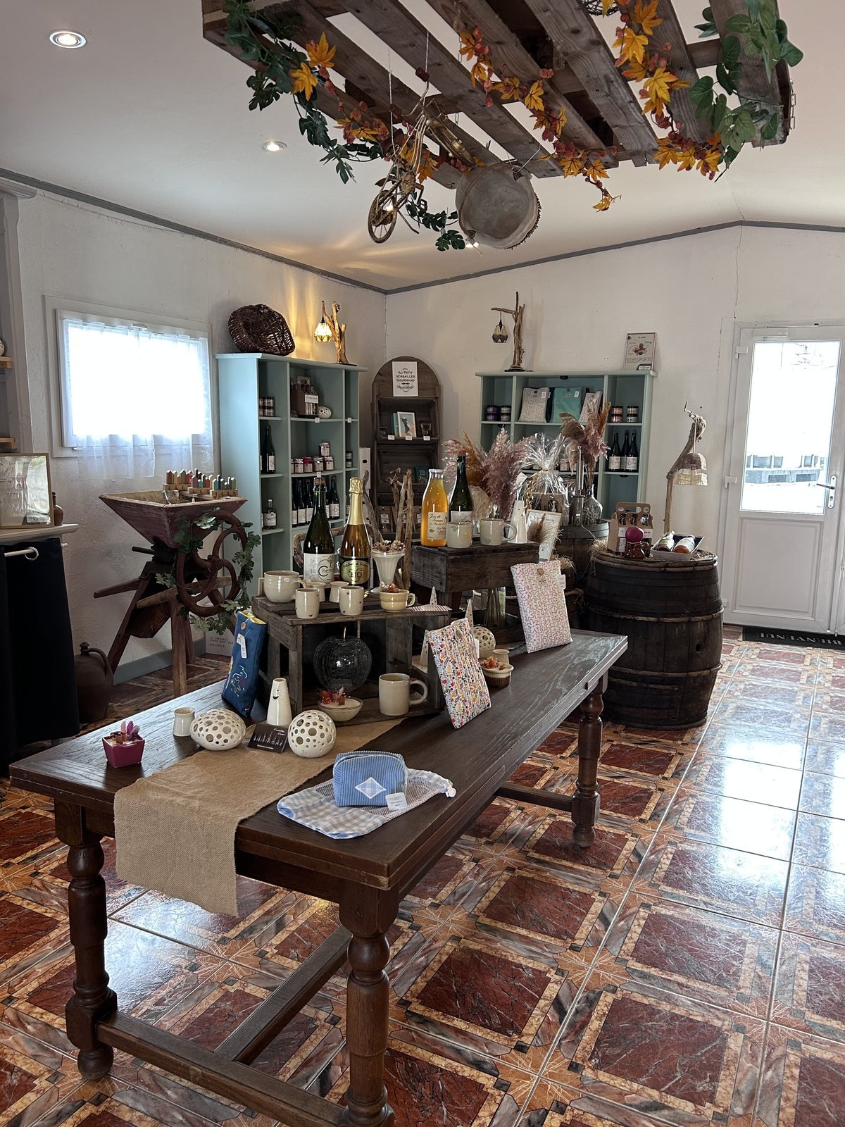 Intérieur du magasin de la Cidrerie de la Chesnaie, avec la grande table, le pressoir et les tonneaux