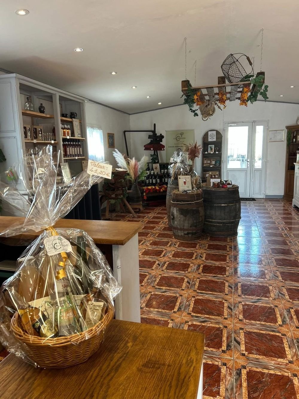 Intérieur du magasin de la Cidrerie de la Chesnaie, avec le vieux pressoir et les tonneaux